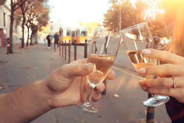 glasses of toast chin chin, hands with glasses of white wine in a street cafe