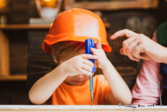 Child with a screw-driver. Kid boy using a screw driver. Early childhood education concept.