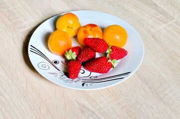 Group of fresh ripe apricots and strawberry  in plate,  ready to eat, Sofia, Bulgaria 