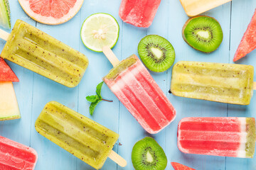 Healthy Whole Fruit Popsicles with Berries Kiwi watermelon cantaloupe on wooden vintage table
