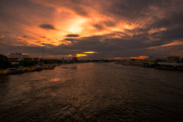 The blurred abstract background of the evening sun shining on the river is naturally golden yellow, the beauty of the clouds and the weather conditions of the day.