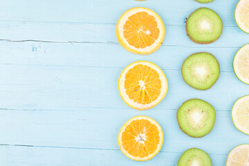 Fruit background. Colorful fresh fruit on Blue wooden board. Orange, kiwi,  lemon，Flat lay, top view,