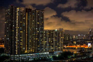 The high angle background of the city view with the secret light of the evening, blurring of night lights, showing the distribution of condominiums, dense homes in the capital community