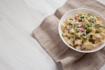 Homemade Macaroni Salad in a white bowl, low angle view. Copy space.