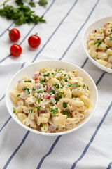 Homemade Macaroni Salad in white bowls, side view.