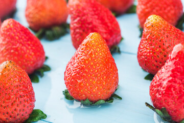 Bunch of fresh strawberries on wooden board background