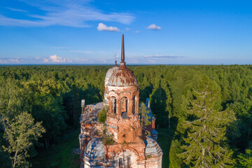 Bell tower of the abandoned old Trinity Church (Life-Giving Trinity in Yazvishchi) close-up on a sunny July evening. Novgorod region, Russia