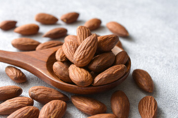 Almonds  in wooden spoon on gray background,copy space.
