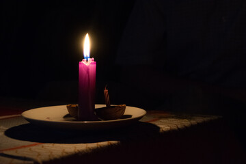 purple warm candle lit in the dark christmas tradition