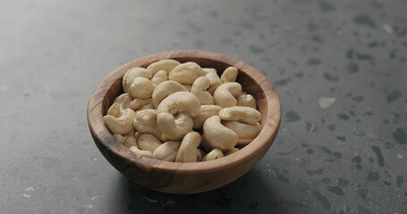 cashew nuts in olive bowl on terrazzo countertop