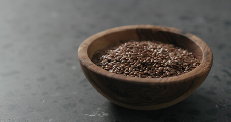 flaxseed in olive bowl on terrazzo countertop with copy space