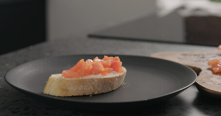 bruschetta with cream cheese and salted trout on black plate