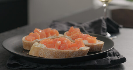 bruschetta with cream cheese and salted trout on black plate