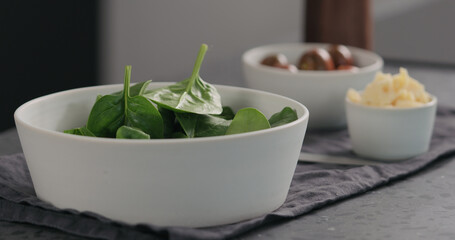 d fresh spinach leaves in white bowl