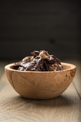 homemade dark chocolate with hazelnuts in wood bowl