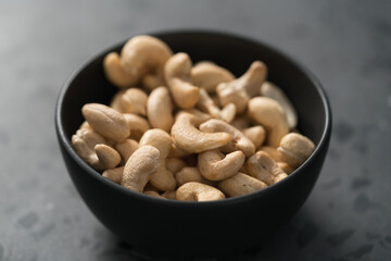 roasted cashew in black bowl on terrazzo countertop