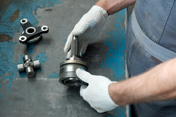 A mechanic checks the quality of parts before replacing them on a passenger car. Close-up of the...