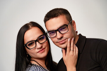 Portrait of stylish young couple. Macho man and woman both wearing glasses.
