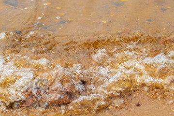 In a small russian town in a park on the shore a wave washes sand with stones