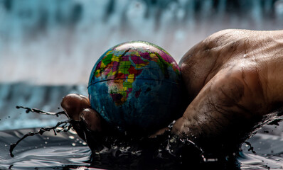 Earth in the shape of a globe in an petroleum stained hand. Concept of eco friendly behavior and...