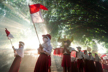 Indonesia 17 August 2020: Student holding Indonesian flag, Indonesia independence day celebration concept in the morning with foggy
