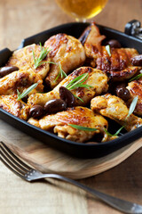 Grilled chicken pieces with kalamata olives and fresh rosemary. Close up.	