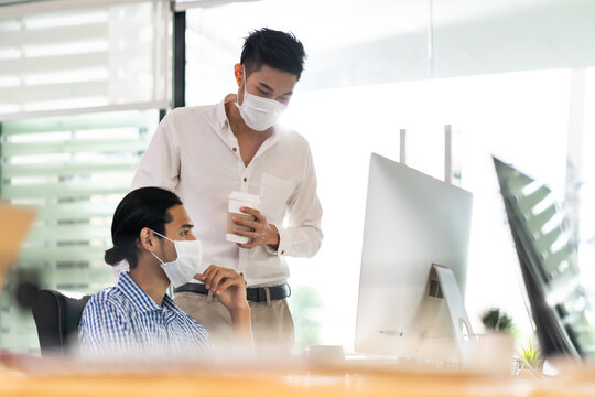 Businessmen wear face mask dicuss in new normal office