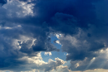 Evening sky with Cumulus clouds and sunset sun