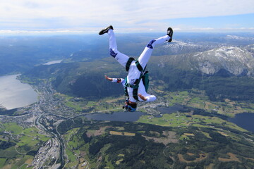 Skydivers over snowy mountains in Norway