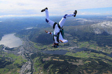 Naklejka na ściany i meble Skydivers over snowy mountains in Norway