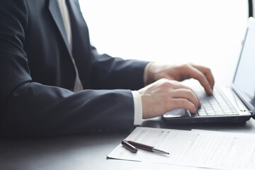 Manager works at a laptop in the office. Businessman makes an online transaction. Trading on the exchange via the Internet.