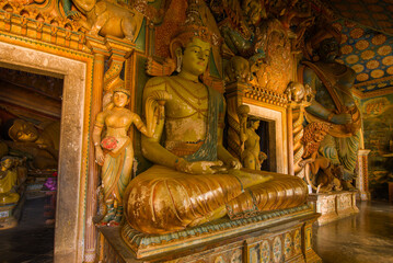 At the ancient sculpture of the seated Buddha. Fragment of the interior of the inner gallery of the ancient Buddhist temple Wewrukannala Buduraja Maha Viharay. Dikwella, Sri Lanka
