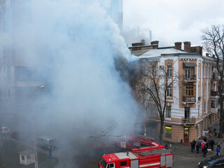 Odessa, Ukraine - December 29, 2016: A fire in apartment building. Strong bright light and clubs, smoke clouds window of their burning house. Firefighters extinguish fire in house. Work on fire stairs