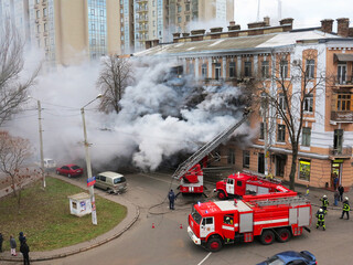 Odessa, Ukraine - December 29, 2016: A fire in apartment building. Strong bright light and clubs, smoke clouds window of their burning house. Firefighters extinguish fire in house. Work on fire stairs