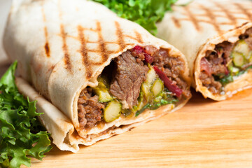Wraps with marinated beef and pickles.