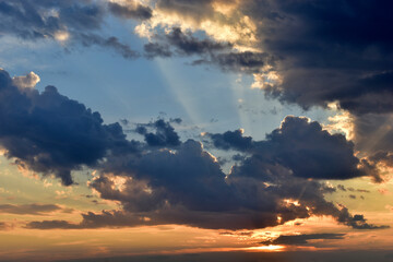 Obraz premium Evening sunset sky with yellow blue clouds and sun rays