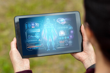 Close-up of a tablet in hands depicting a medical technology hologram graphics. medicine of modern times. Copy space.