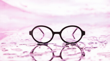 Tools for vision correction. Glasses and lenses with diopters on the background of splashes and...