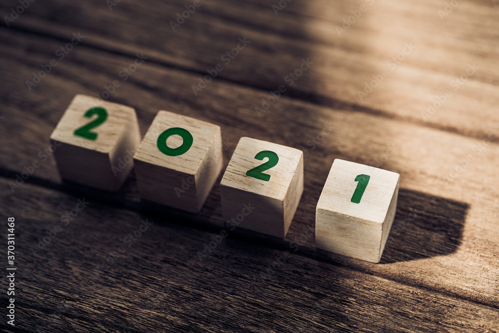 Poster 2021 happy new year on wood block on wood table and concrete wall with sunlight from window.hope new