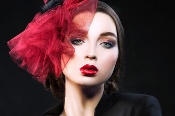 Beauty face of fashion model woman with bright make-up, red hat, perfect skin. Black background