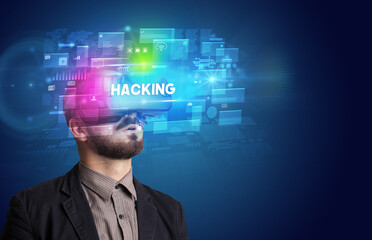 Businessman looking through Virtual Reality glasses with HACKING inscription, innovative security concept