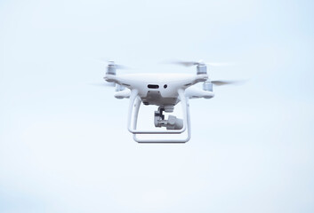 Quadcopter with camera aboard flying in sky