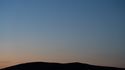 Natural background. The sky before sunrise. The firmament after sunset. Colored smooth transitions from blue to orange. Colorful clear sky with no clouds at dusk after sunset.
