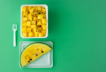 ripe yellow watermelon cut into pieces in a plastic white bowl