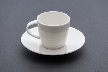 Coffeecup and saucer isolated on dark background