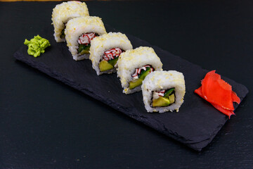 Uramaki sushi rolls with surimi on a black slate