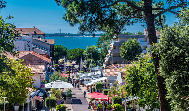 France, Gironde, Arcachon, cafe-restaurant of the pedestrian street leading to the Moulleau pier, and the lighthouse of the Cap-Ferret in the backgrou