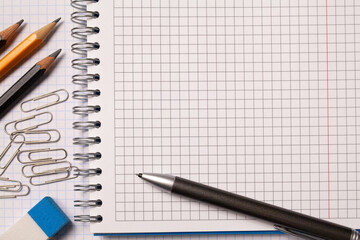 Squared notebooks, pencils, eraser, pen, paper clips. The concept is back to school or office. Copy space.