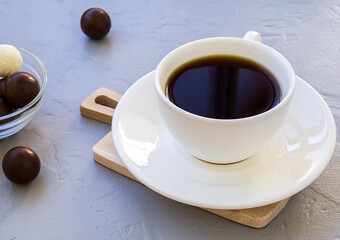 A Cup of coffee and candy in the morning. Still life on a grey concrete background.