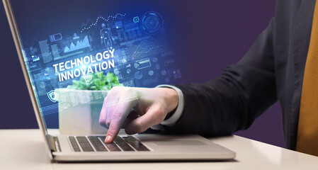Businessman working on laptop with TECHNOLOGY INNOVATION inscription, cyber technology concept